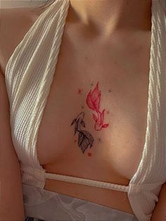 a woman's chest with a butterfly tattoo on her left side, and stars above the breast