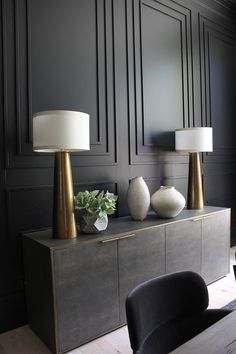 two lamps sitting on top of a dresser in a room