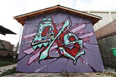 a purple building with colorful graffiti on it