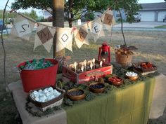 a picnic table with food on it and buntings hanging from the line above