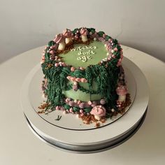 there is a green cake with pink flowers on it