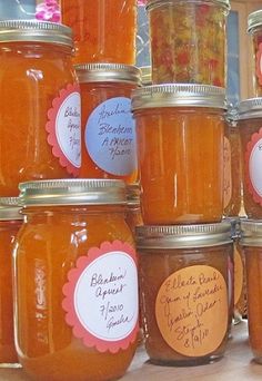 several jars filled with different types of honey on a counter top next to each other