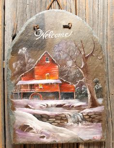 a welcome sign hanging on the side of a wooden fence with a red barn and stream