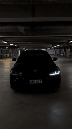 a car parked in a parking garage with no lights on it's headlight