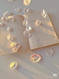 an open book sitting on top of a white table covered in water drops and bubbles