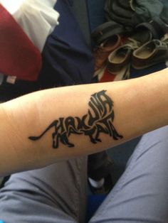 a person with a tattoo on their arm that has a lion design on the side