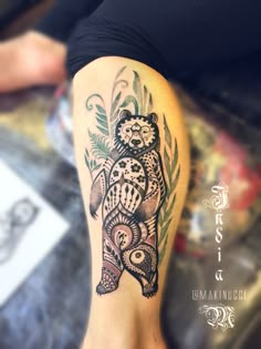 a woman's leg with an owl and leaves tattoo design on the lower leg