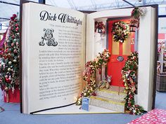 an open book with christmas wreaths and decorations on the front door is displayed in a store