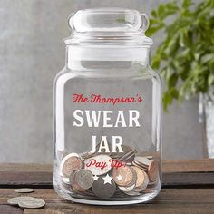 a glass jar filled with coins on top of a wooden table