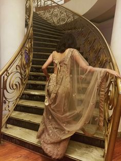 a woman is standing on the stairs in a dress