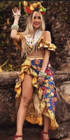 a woman in a colorful dress posing for the camera with her hand up to her head