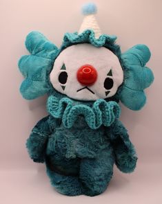 a blue teddy bear with a clown hat on