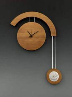 a wooden clock with two pendulums attached to it's sides and a face drawn on the side