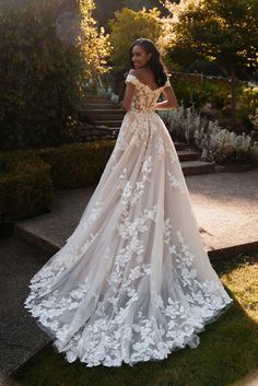 a woman in a wedding dress standing on some steps