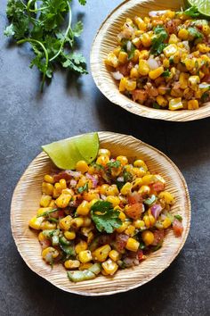 two bowls filled with corn and cilantro on top of a black countertop