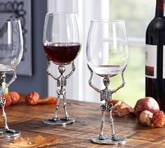 three wine glasses sitting on top of a wooden table