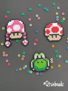 three pixel art magnets are shown on a table with sprinkles around them