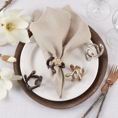 a place setting with napkins, silverware and flowers