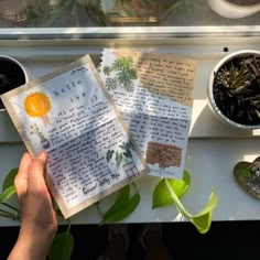 someone holding up some papers with plants in them