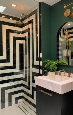 a bathroom with black and white stripes on the walls, a sink and mirror in it