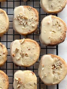 there are many donuts with icing and nuts on top of the cooling rack