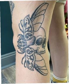 a woman's leg with a skull and butterfly tattoo on it