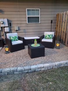 outdoor furniture is sitting on gravel in front of a house