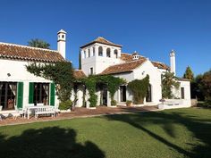 a large white house with green shutters on the front