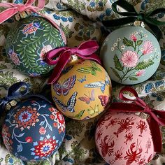 four ornaments with bows are on a bed