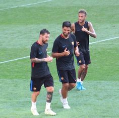 three soccer players are walking around on the field with their hands in each other's pockets