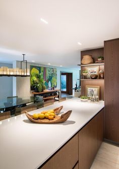 a bowl of lemons sits on the counter in this modern kitchen area with open shelving