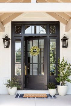 a black front door with two white planters