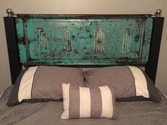 a bed with two pillows on it and an old green headboard over the top