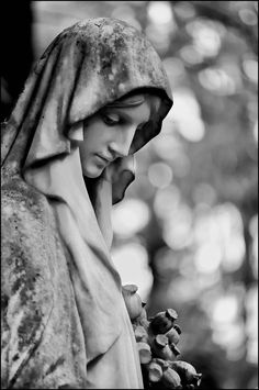 black and white photograph of the statue of mary holding grapes in her hands, looking down