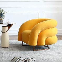 a yellow chair sitting on top of a gray rug next to a table and vase