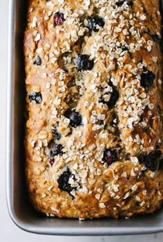 a loaf of oatmeal and blueberry bread in a pan