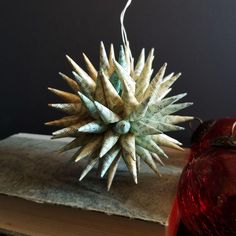 an ornament on top of a book next to some ornaments