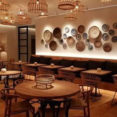 an empty restaurant with wooden tables and wicker baskets hanging on the wall above them