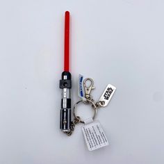 a light saber keychain with a star wars message on it and a red light