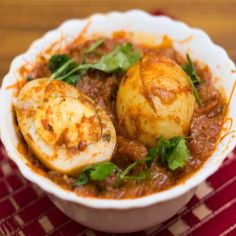 a bowl filled with some kind of food on top of a red and white cloth