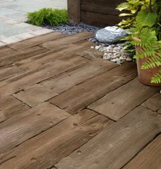 a wooden deck surrounded by plants and rocks