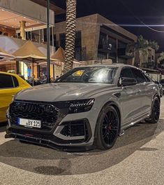 a grey car parked in front of a yellow car