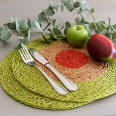 two forks and an apple on a place mat