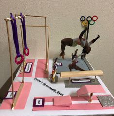 a table topped with different types of gymnastics equipment and medals on top of each other