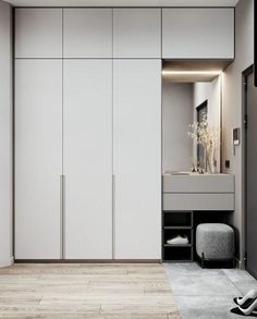 a bedroom with white closets and wooden flooring next to a mirror on the wall