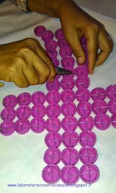 a person cutting up pink circles with a pair of scissors