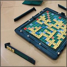 a scrabble game is laying on the floor next to crayons