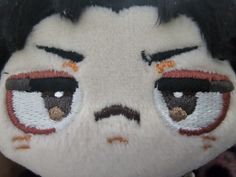 a close up of a stuffed animal with an evil look on it's face