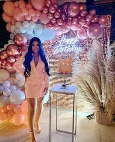 a woman is standing in front of balloons