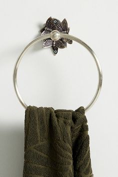 a towel ring with a flower on it hanging from the side of a white wall